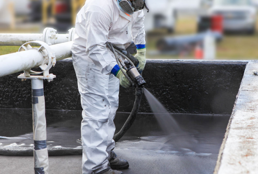Spraying a coating inside a containment pit